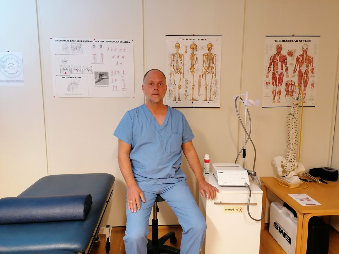 Fysioterapuet Bjørn H. Engseth står ved siden av pasientseng på fysioterapiklinikken